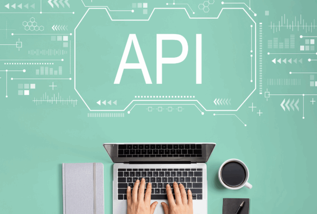 图片 5：绿色背景上印有大写字母 API。图片底部还有一台笔记本电脑和两只人手。