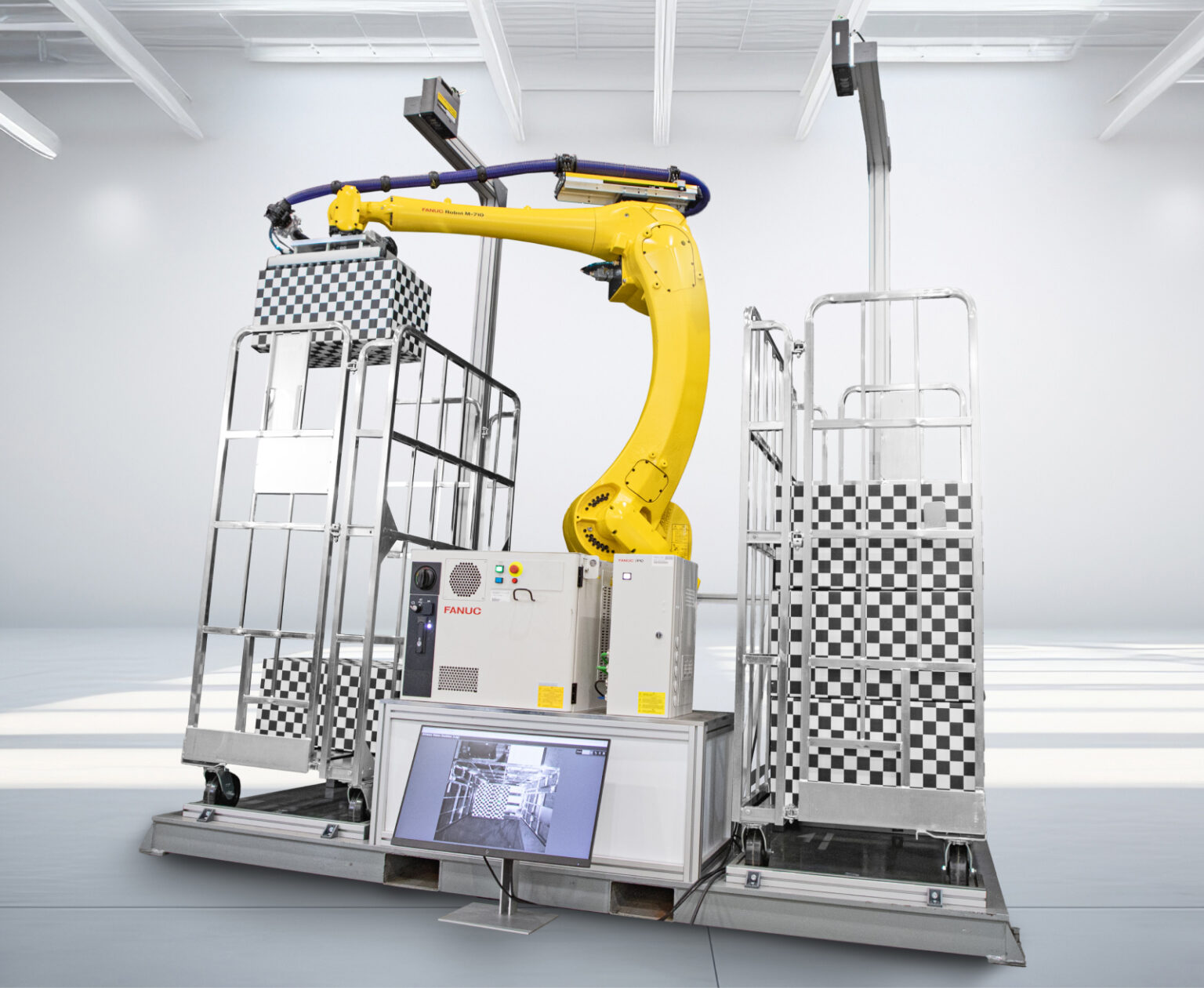 FANUC 的 M-710 箱式码垛机拾取方格箱并将它们放置到托盘上。